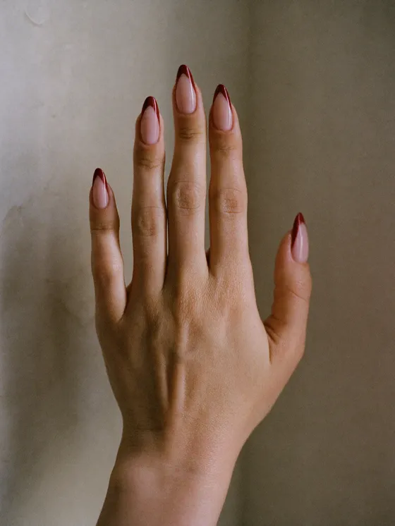 A modern french manicure with a deep terracotta tip